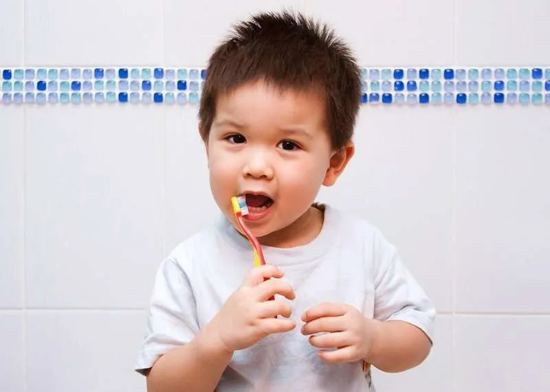 a young child brushing his teeth after a pediatric dental treatment at saddleback dental