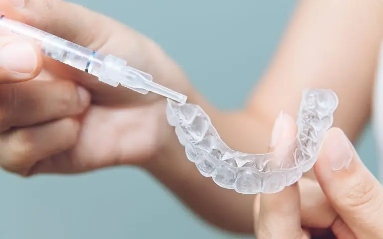 Dentist Applying Whitening Gel During Step 1 of Teeth Whitening Process